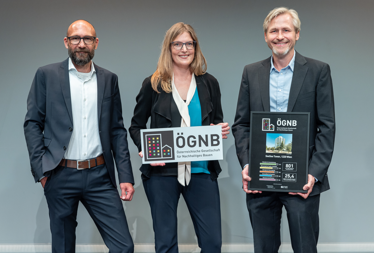 Menschengruppe, die eine Auszeichnung hält und in die Kamera lacht